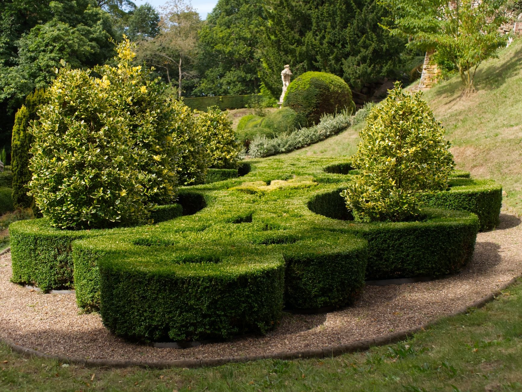 Formal topiary garden terraced across a green hillside